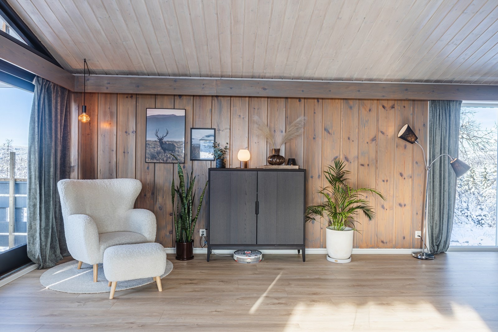 Plass til sittegruppe ved peisen med lett atkomst til overbygget terrasse med utsikt over uteområdet og kulturlandskapet ellers. Galleribilde