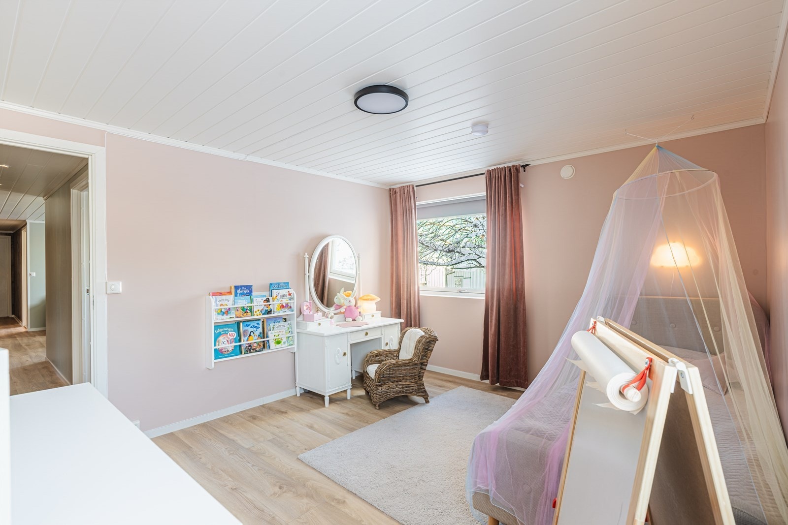 Rommet har store vinduer som gir godt med naturlig lys og utsikt til hagen. Galleribilde