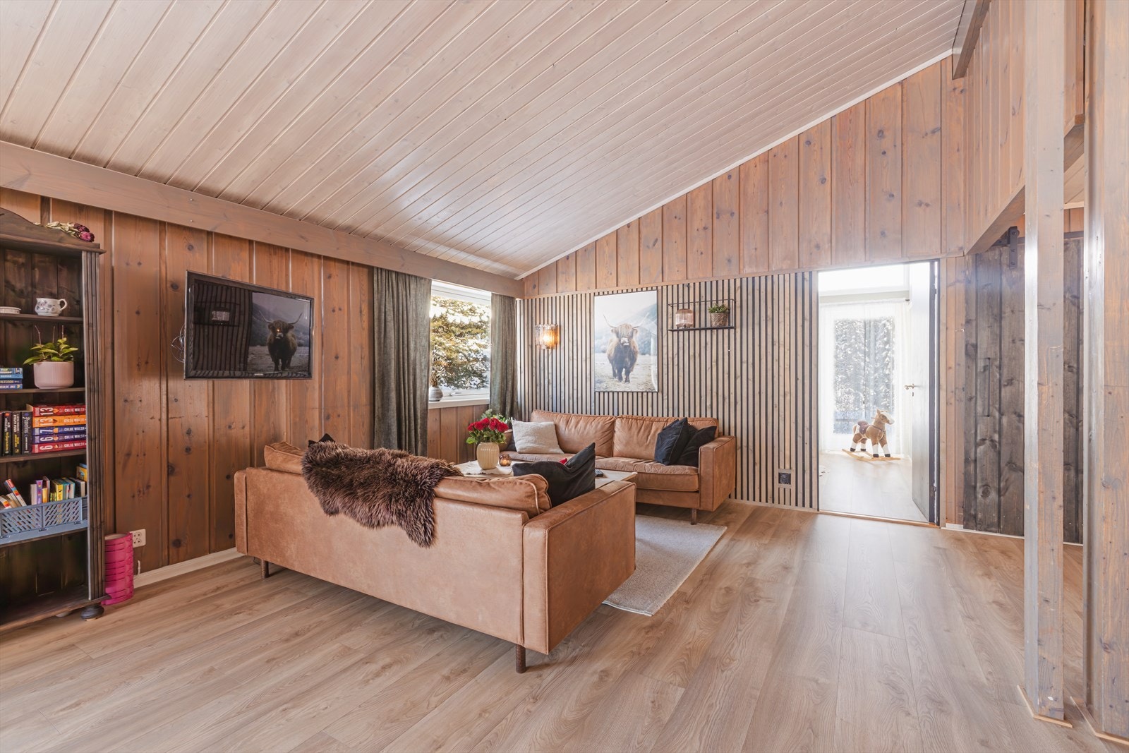 Panelvegger og paneltak skaper en varm atmosfære i stua Galleribilde