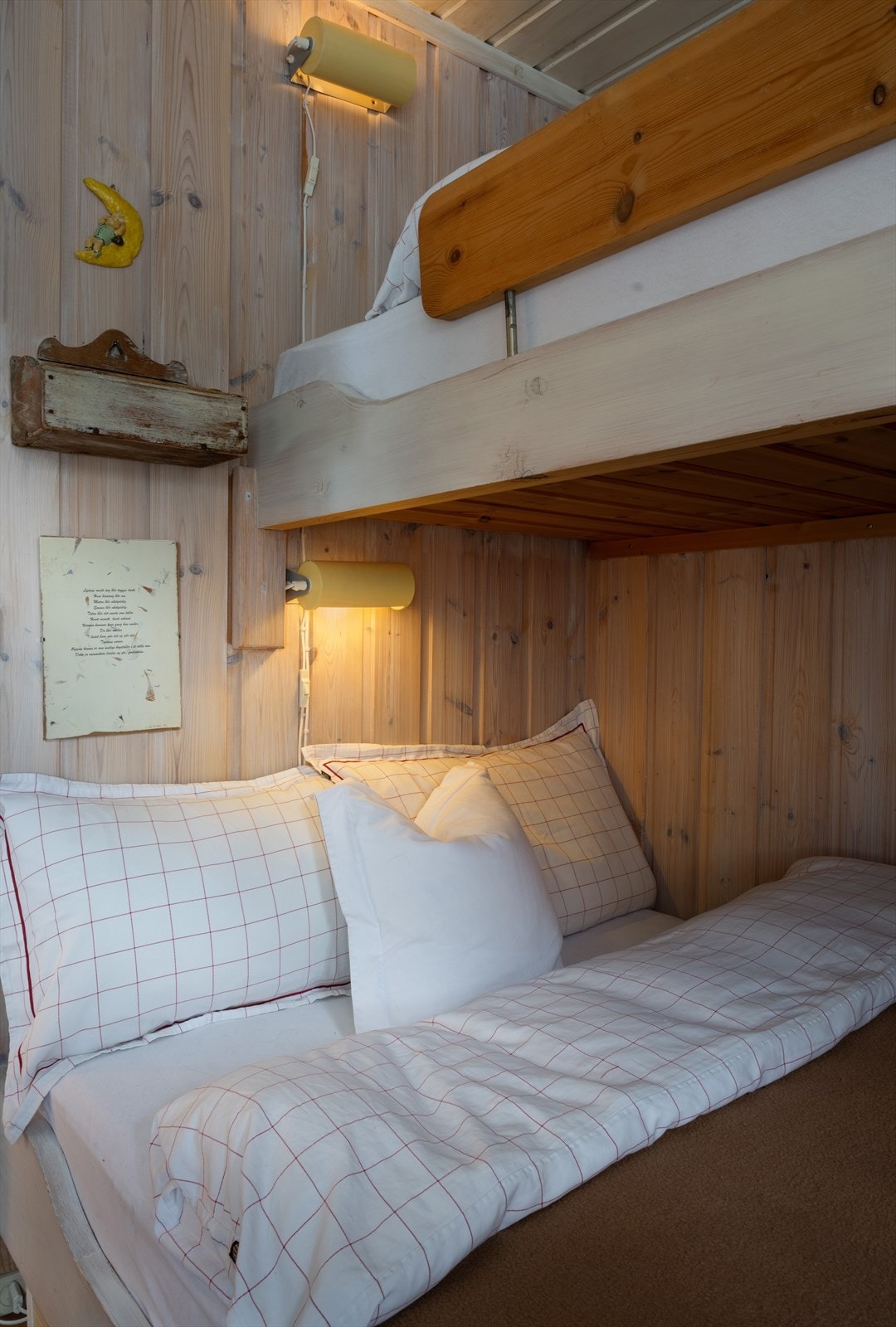 Køyesengen er plassert langs veggen med leselamper montert for komfort. Galleribilde