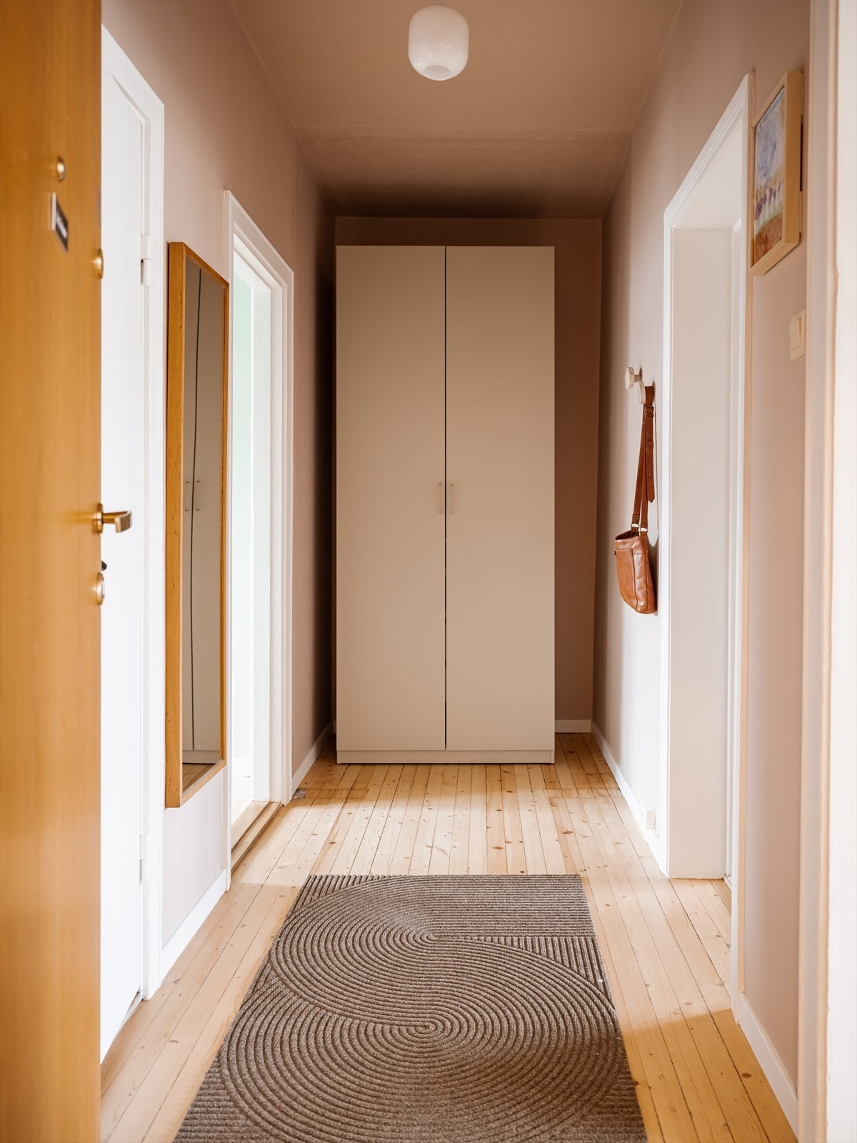 Entréen har en praktisk utforming med veggmontert knaggrekke, og det er et garderobeskap som gir svært gode oppbevaringsmuligheter. Galleribilde