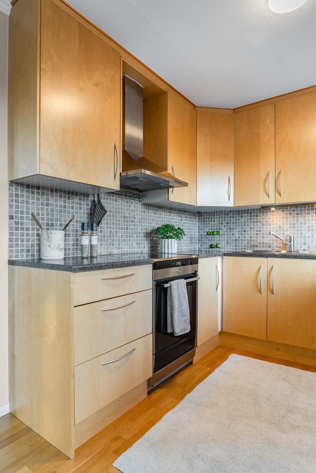 Kjøkkenet har innredning med glatte fronter og benkeplate av laminat Galleribilde