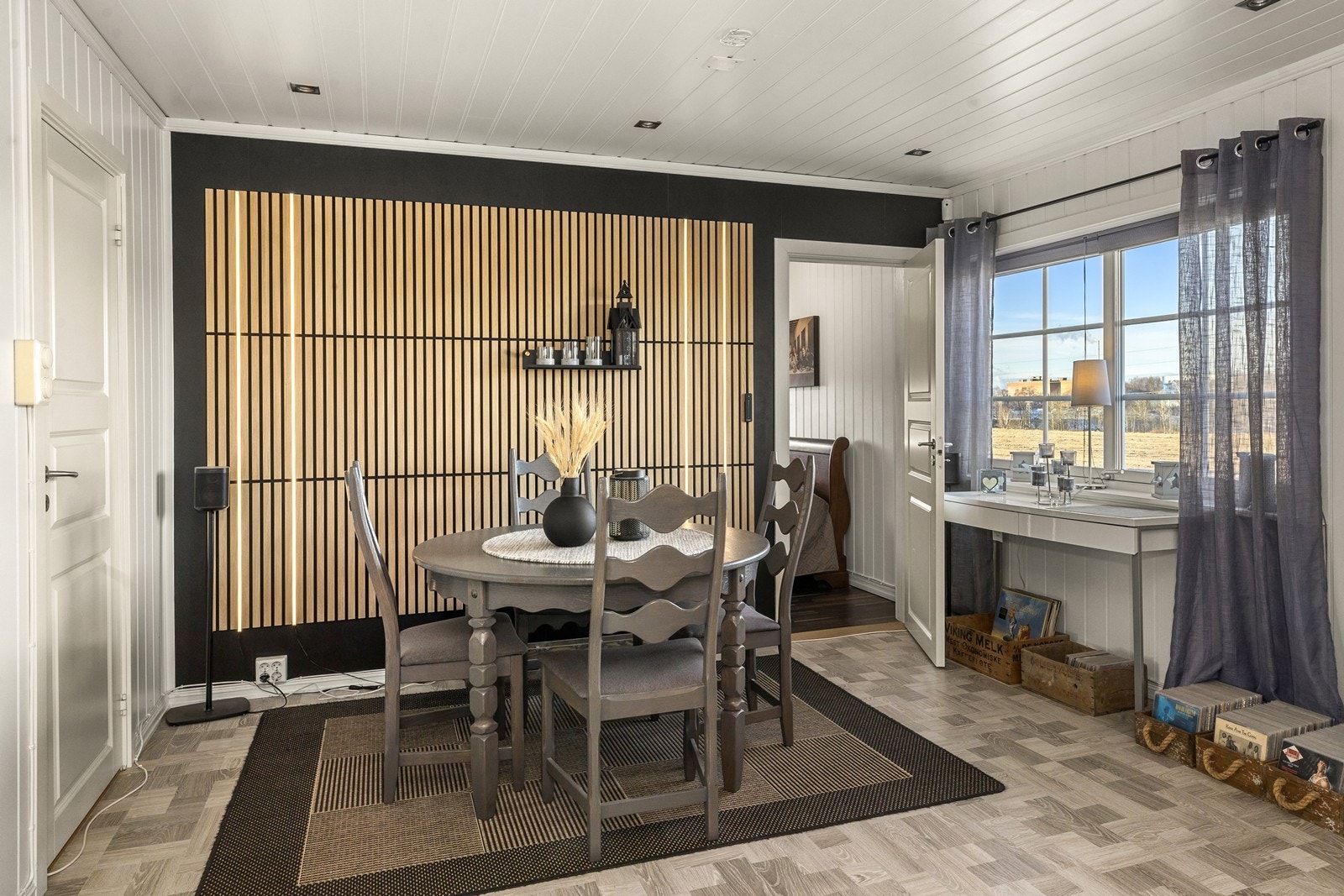 Spisestuen har en fondvegg med spileplater som definerer sonen. Galleribilde