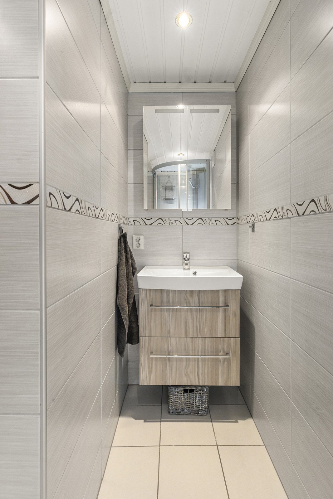 Baderommet har flislagte vegger og gulv, samt servant med skapinnredning. Galleribilde