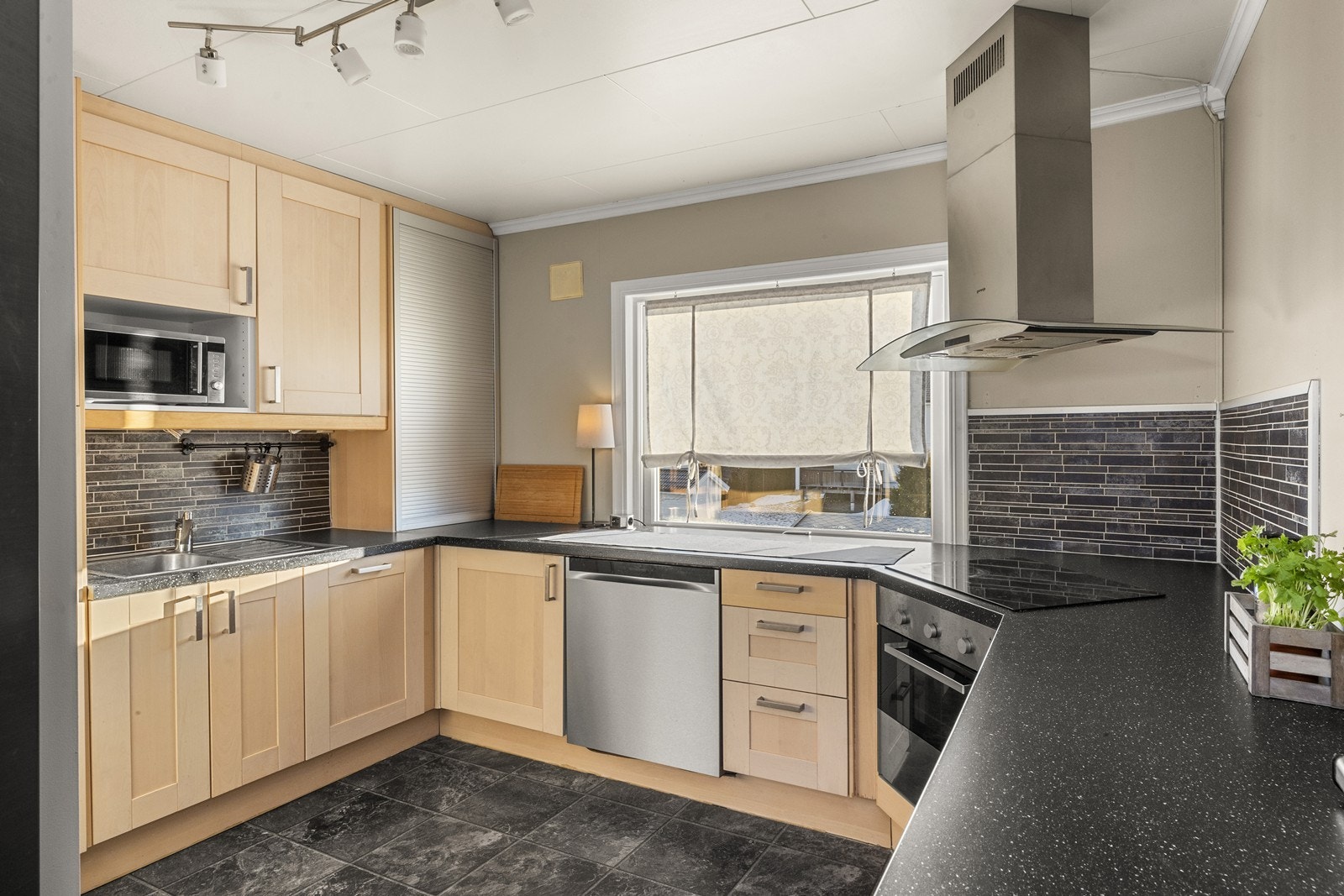 Kjøkkeninnredning med profilerte fronter i heltre og laminatbenkeplate. Galleribilde