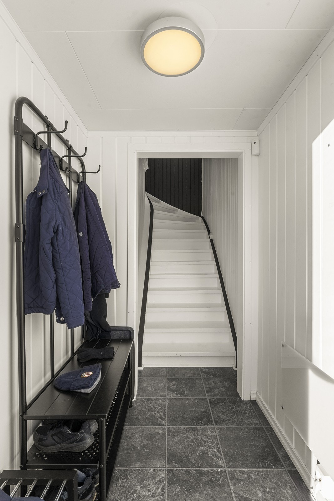 En malt tretrapp leder opp til boligens hovedplan i andre etasje. Galleribilde