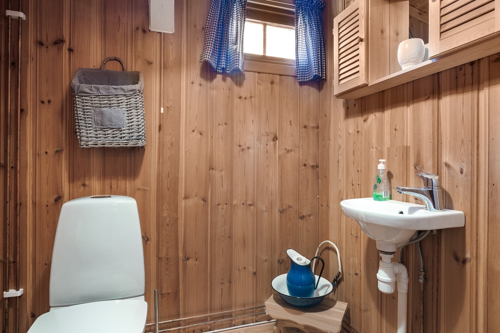 Toalettrom med gulvmontert toalett og servant Galleribilde