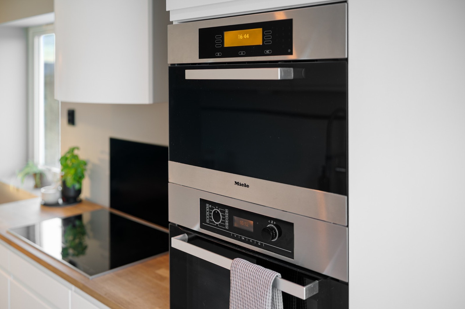 Integrerte hvitevarer fra bl.a. Miele. Stekeovn og mikrobølgeovn er praktisk plassert i arbeidshøyde. Galleribilde
