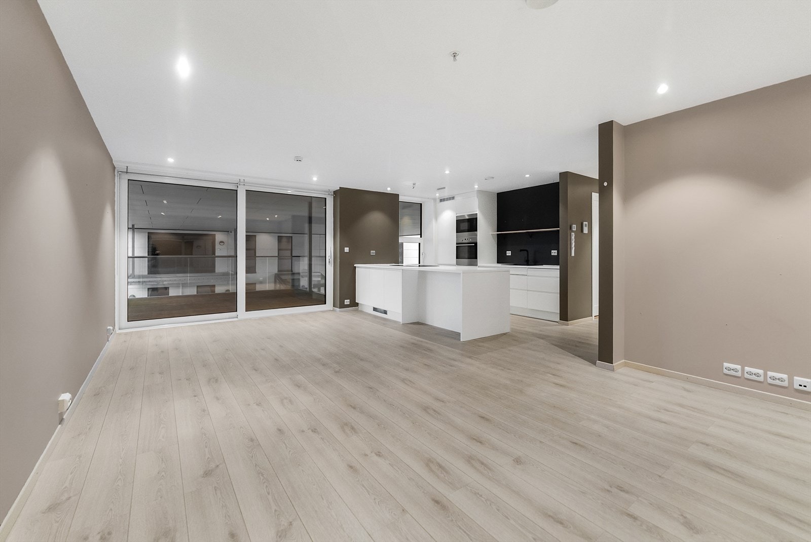 Her kjem du inn i stue og kjøkken som open løysing. Skyvedør ut til overbygd terrasse Galleribilde