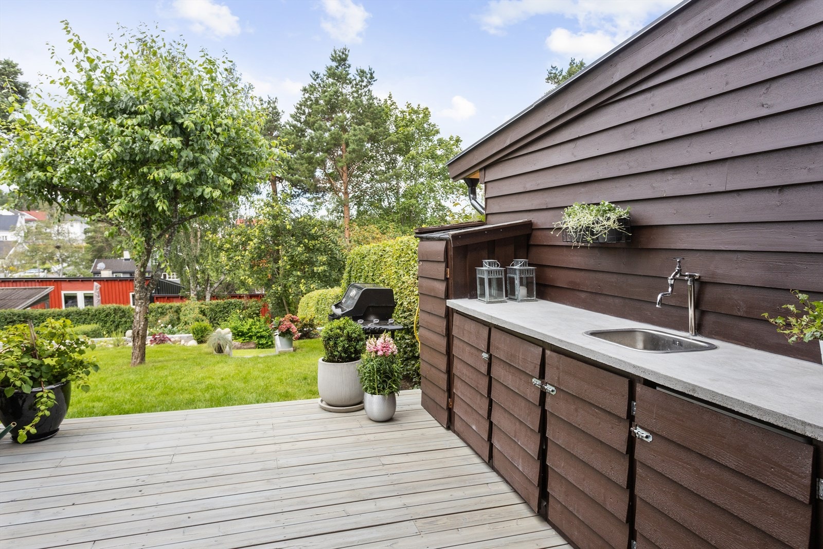 Den store markterrassen har et praktisk utekjøkken med innlagt vann. Her har du oppbevaring til kjøkkenutstyr, eget kjøleskap og mer til for at hobbykokken skal trives. (Bildene er tatt tilbake i 2019). Galleribilde