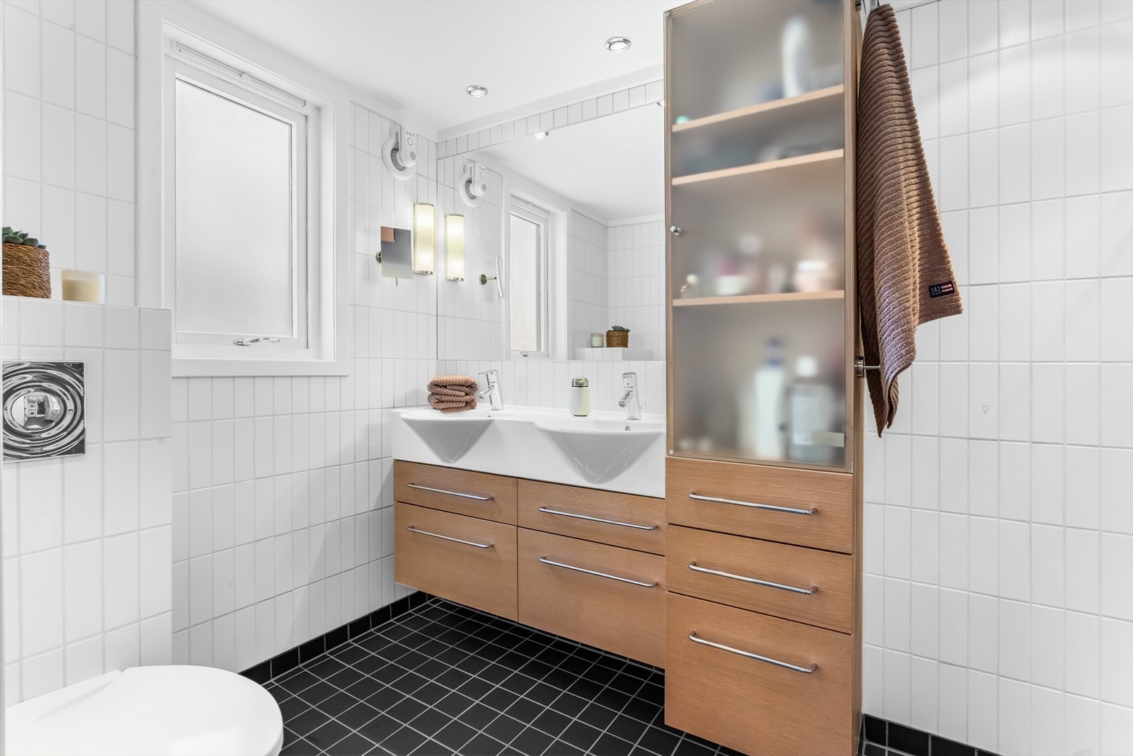 Innredningen består av et servantskap med dobbel servant, ett-greps blandebatterier, et innmurt speil og et høyskap. Galleribilde