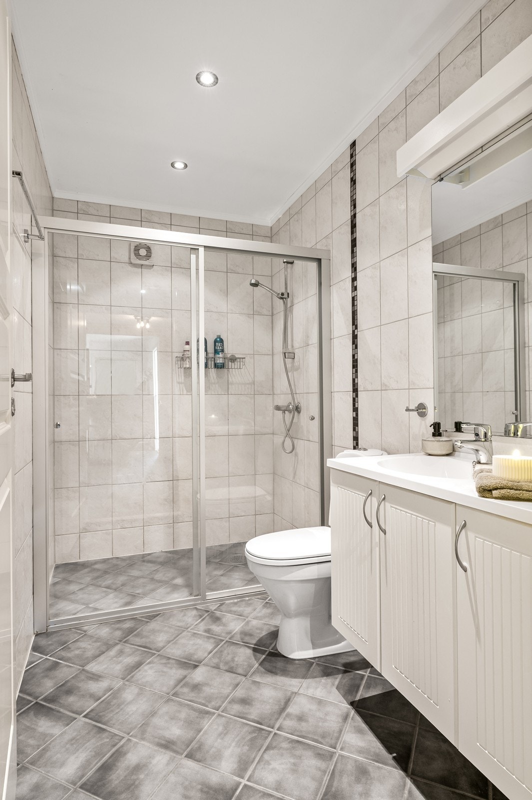 Rommet er utstyrt med dusjhjørne, toalett og en innredning med nedfelt servant. Galleribilde