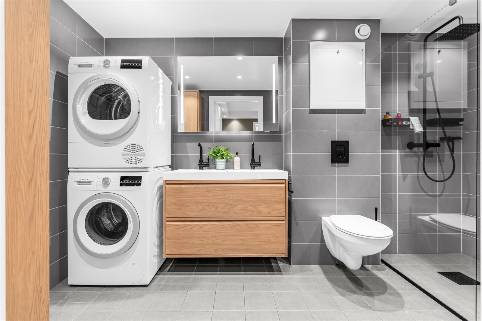 Boligens to baderom er helfliset i moderne fargepaletter og rehabilitert i regi av borettslaget i 2024. Galleribilde