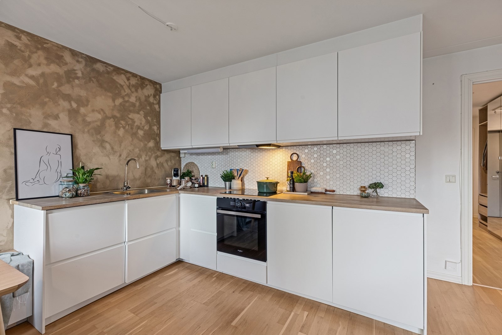 Kjøkkenet er tidløst og funksjonelt, med rikelig skapplass og god benkeflate. Kvalitetsinnredning og integrerte hvitevarer gjør det både praktisk og elegant. Galleribilde