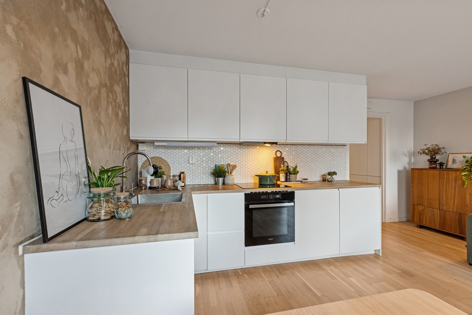 Gode oppbevaringsmuligheter i både over- og underskap, samt romslige arbeidsflater. Integrert kjøle- og fryseskap i benken. Galleribilde