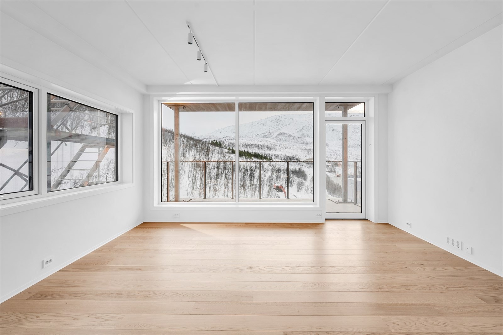 Store vindusflater med rikelig lysinnslipp i kombinasjon med god takhøyde sikrer en luftig og innbydende atmosfære i boligen. Galleribilde