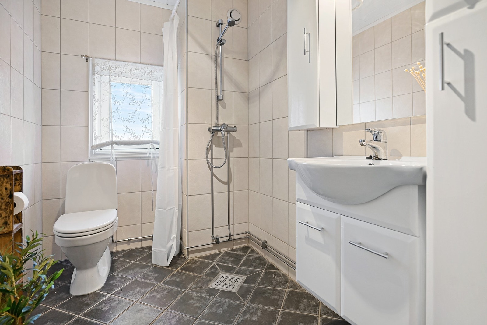 Badet har innredning med nedfelt servant, gulvfestet toalett og dusjhjørne. Galleribilde