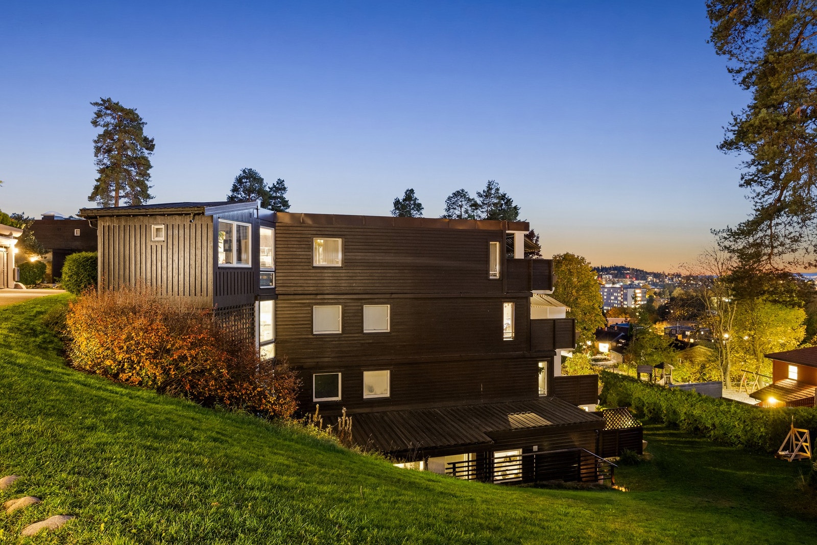 Kveld i Olav Aukrust vei 12 - leiligheten har egen inngang fra bakkeplan, i tillegg til adkomst via felles inngangsparti Galleribilde