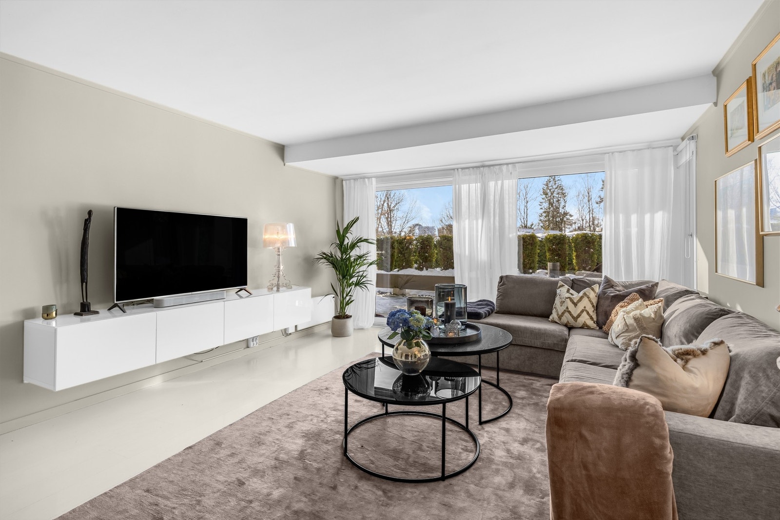 Gulv, vegger og tak i stuen er malt i lyse vennlige farger, og det er god plass til stor sofa og sofabord Galleribilde