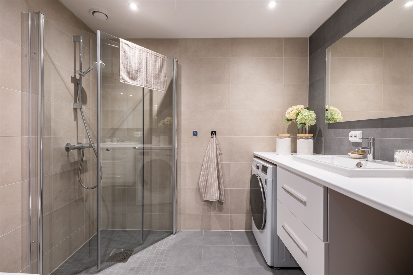 Romslig og delikat bad med store, moderne fliser og gjennomtenkte fargevalg. Galleribilde