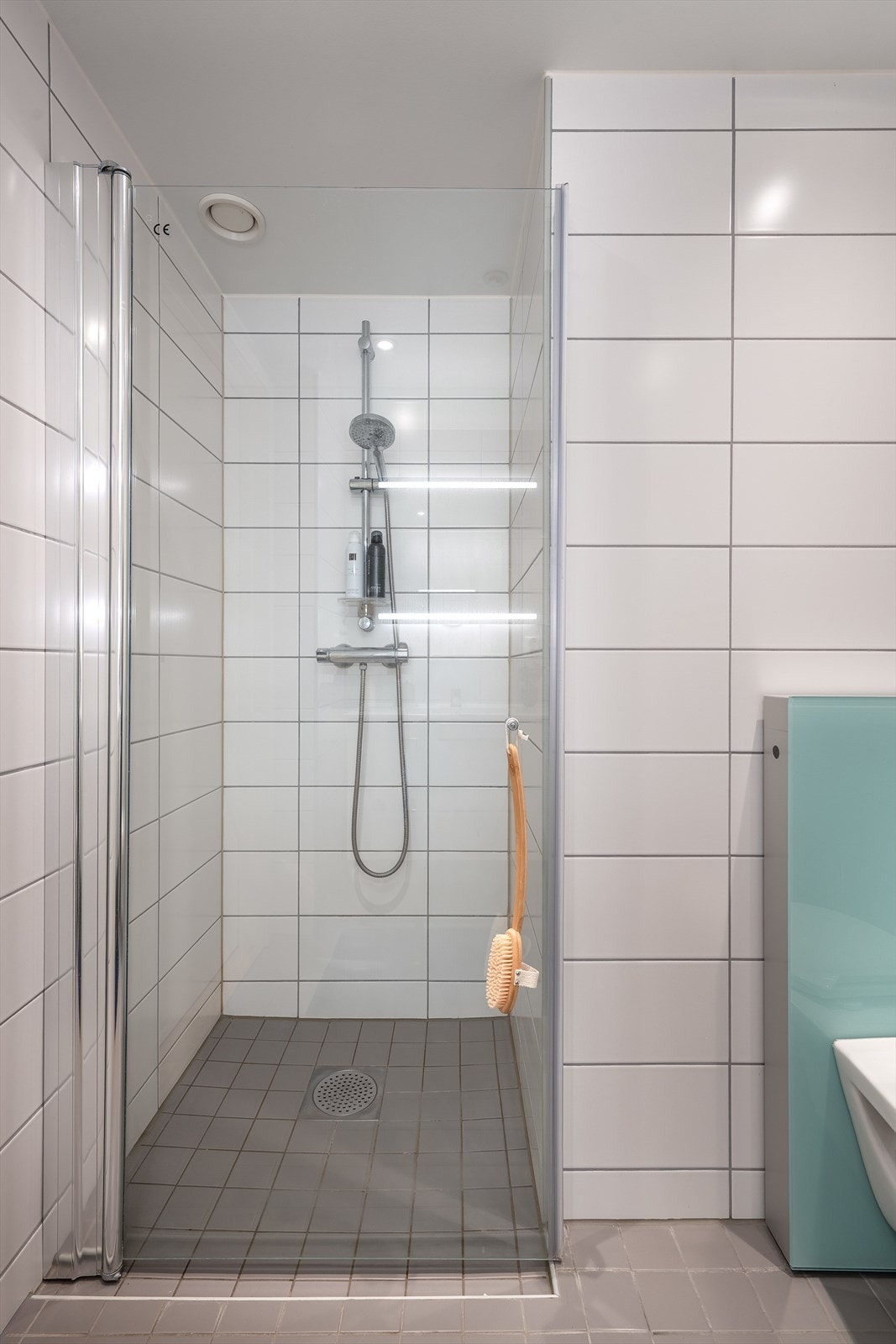 Innredningen består av en servant nedfelt i baderomsinnredning, veggmontert toalett og et dusjhjørne med innfellbare vegger. Galleribilde