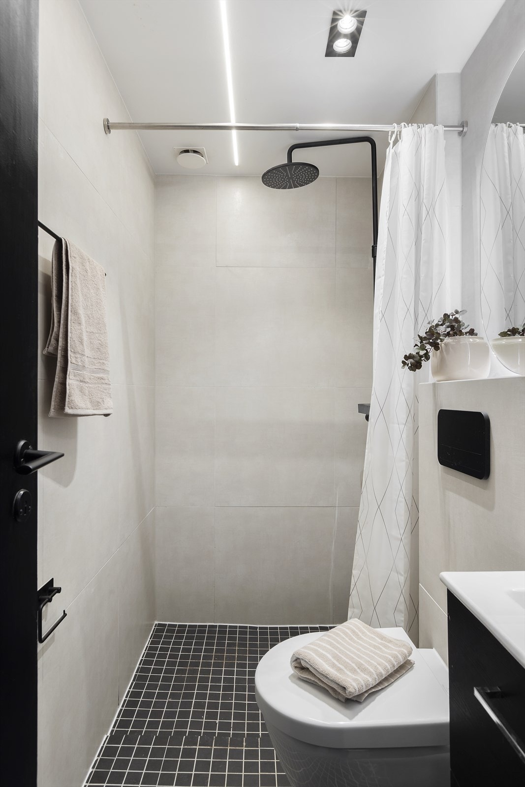 Baderomsinnredning med skap med glatte fronter, veggfestet klosett og regnfallsdusj Galleribilde