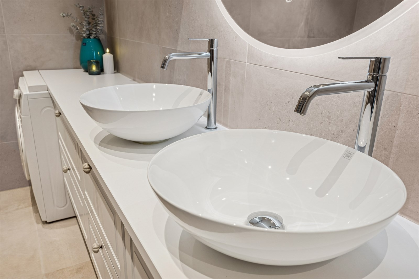 Her får man dobbel servant og det er opplegg for vaskemaskin. God skapplass med både underskap og overskap med profilerte dører, speil med integrert belysning. Galleribilde