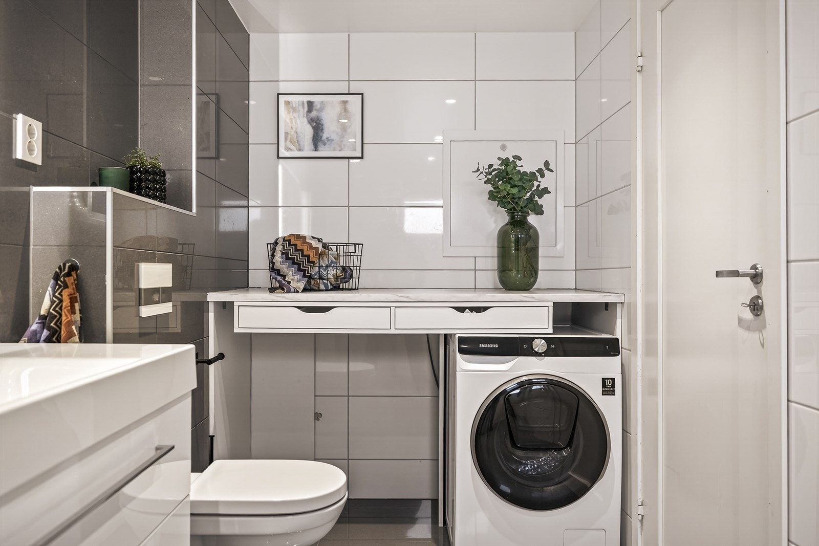 Praktisk bad med opplegg for vaskemaskin og god benkeplass. Galleribilde