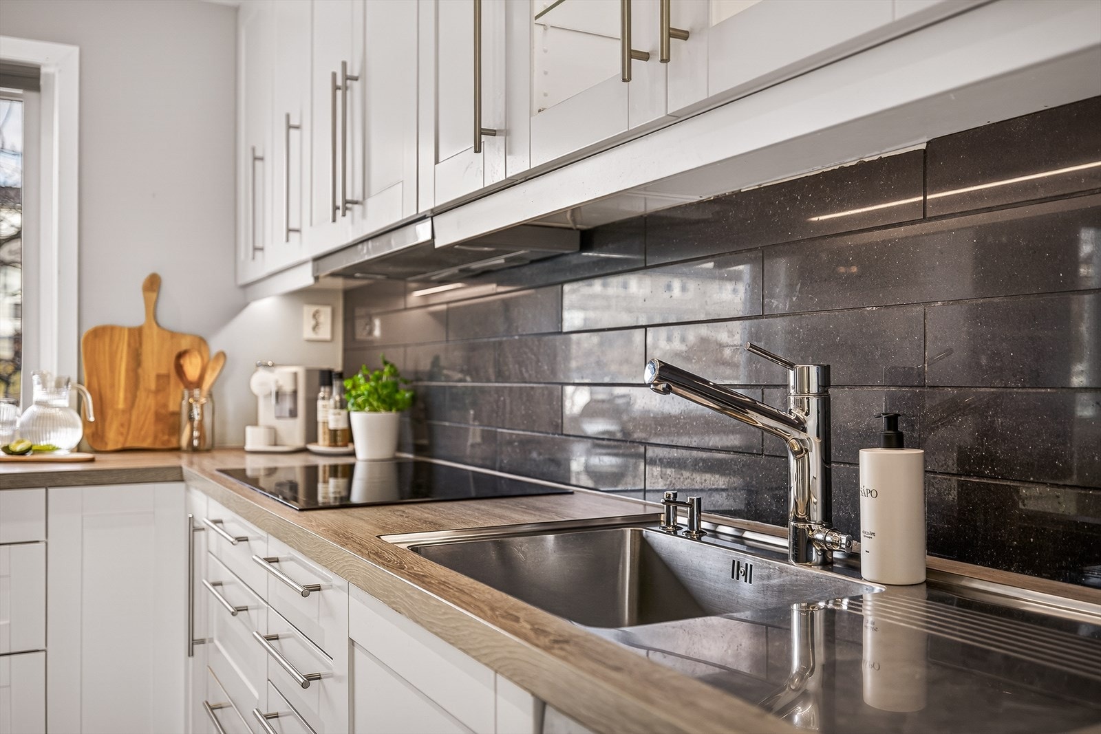 Detaljrik finish med underlimt vask, belysning under overskap og stilrene fronter som gir et helhetlig og moderne uttrykk. Galleribilde