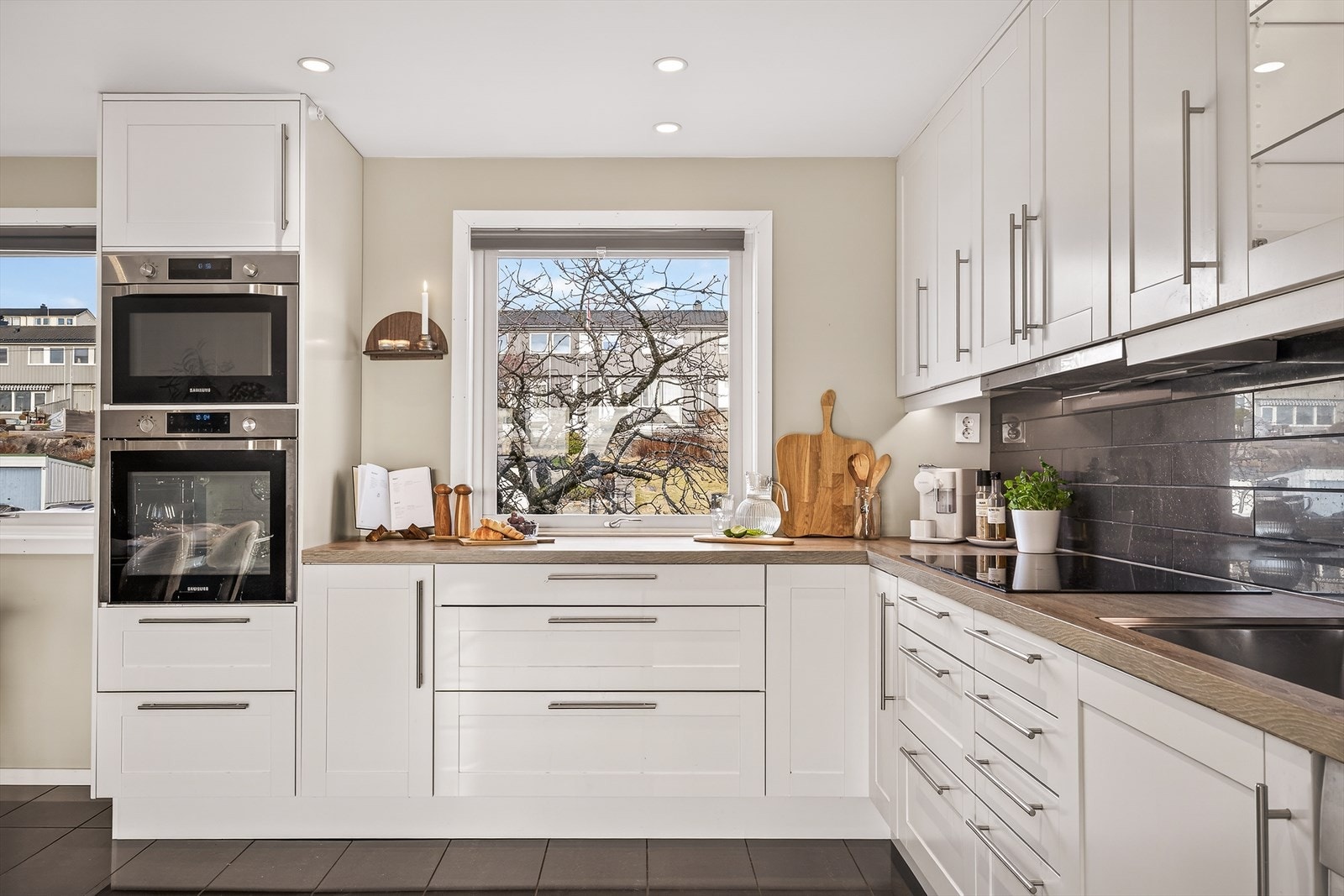 Kjøkkenet har svært gode lysforhold og god benke- og skapplass, noe som gjør rommet både praktisk og behagelig i bruk. Galleribilde