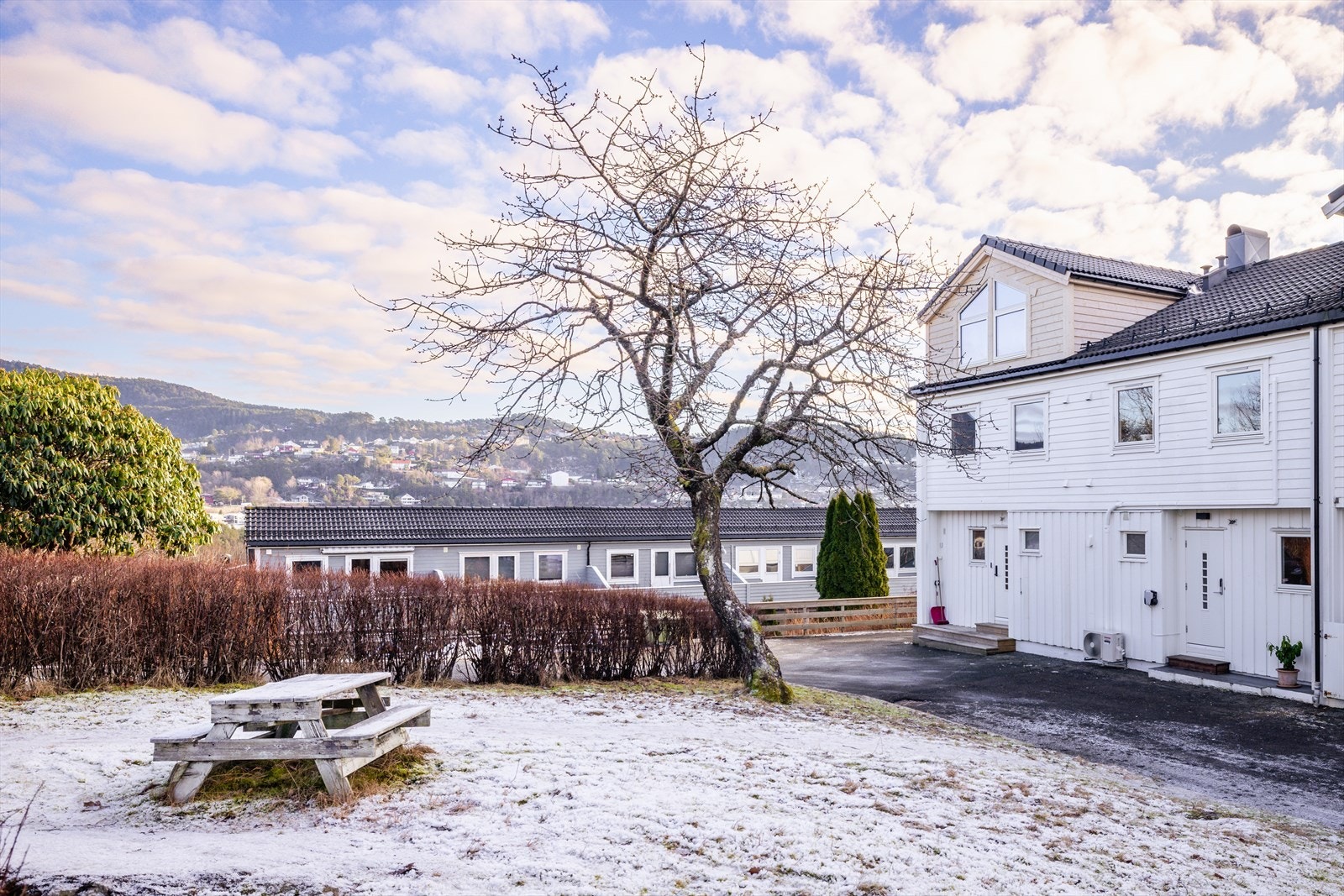 Trivelig uteområde med plen og sitteplass, omgitt av rolige og etablerte boligrekker. Galleribilde