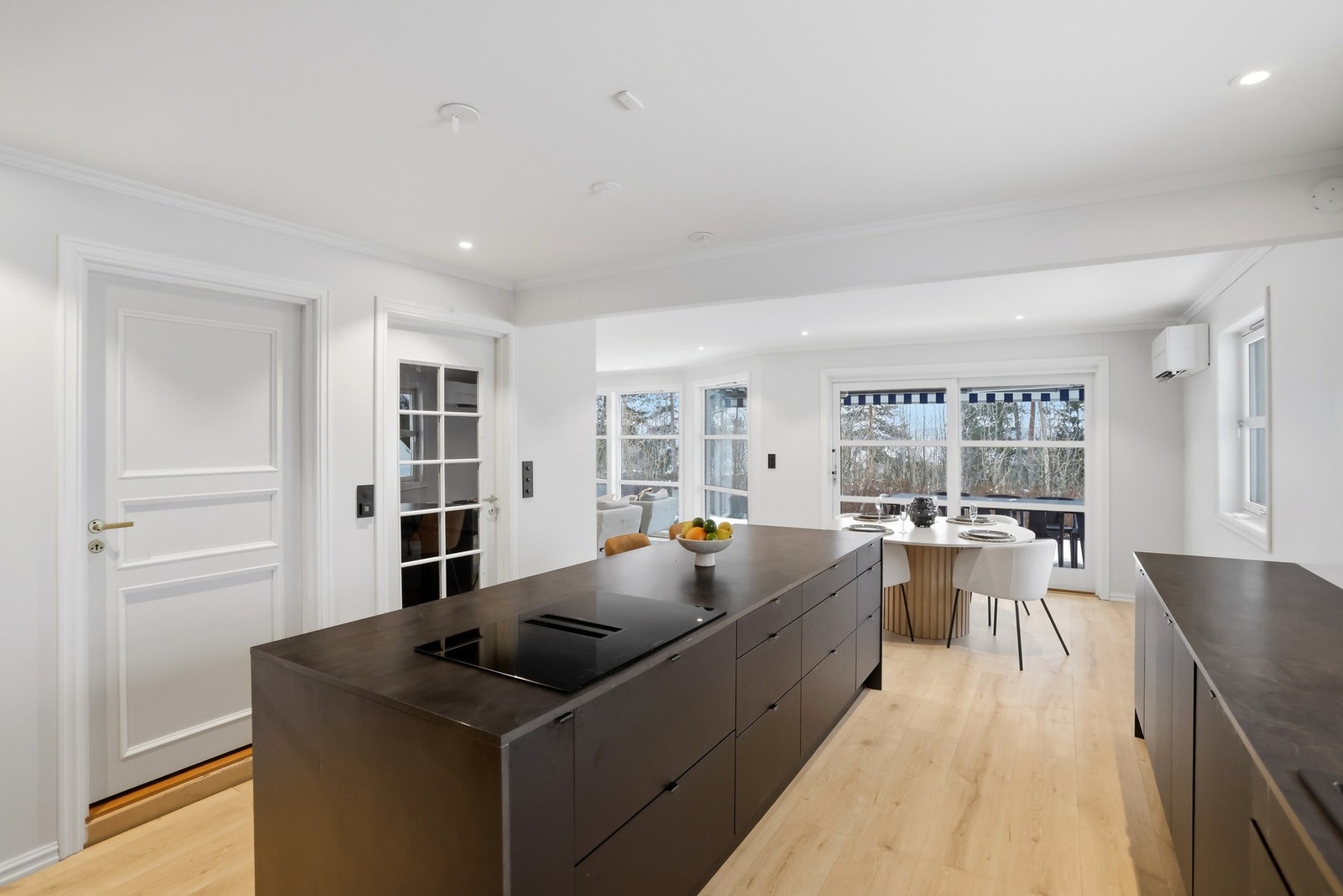 Stor kjøkkenøy med platetopp og rikelig med skap- og benkeplass. Galleribilde