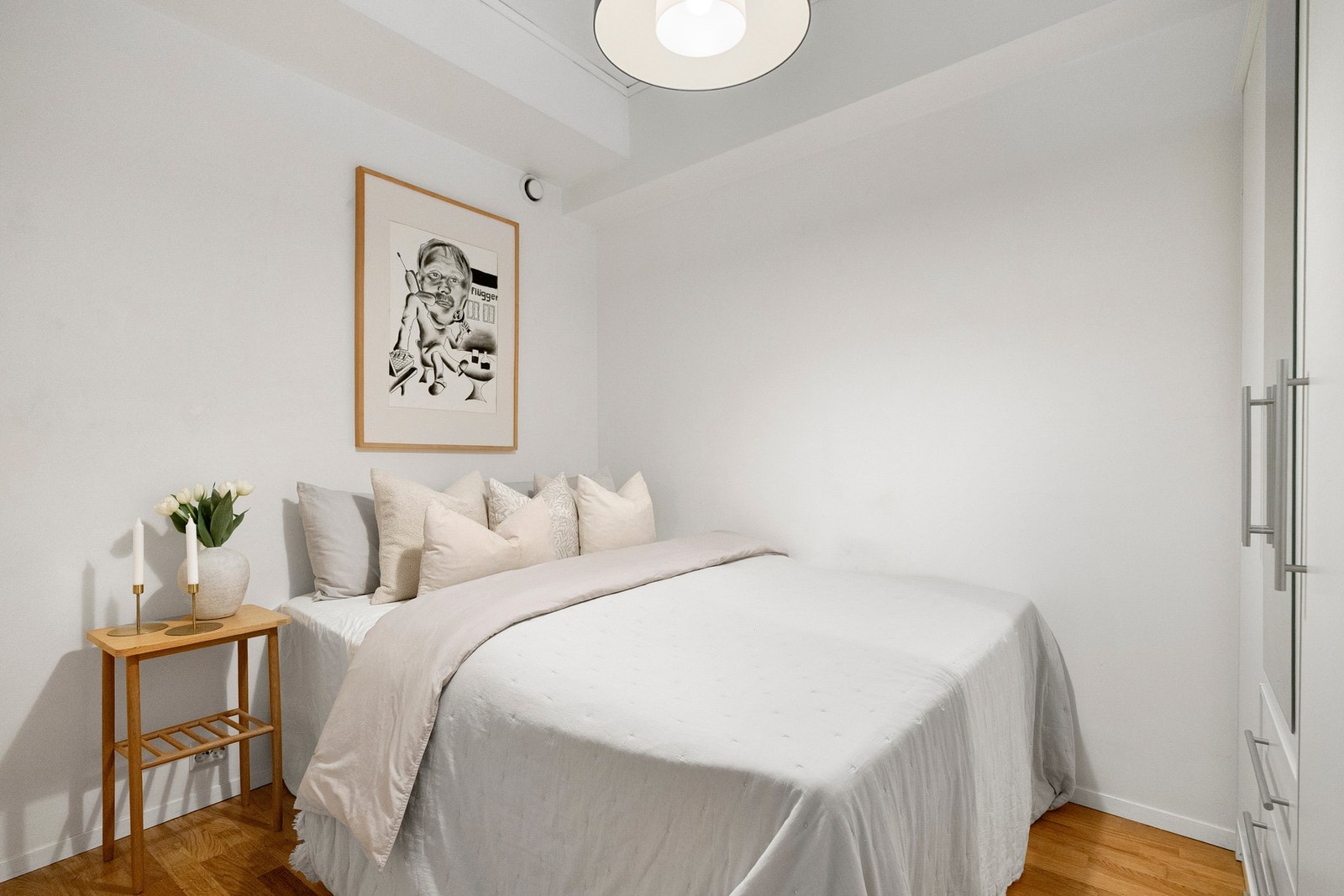 Leiligheten har et romslig soverom med hvite vegger og parkett på gulvet. Galleribilde