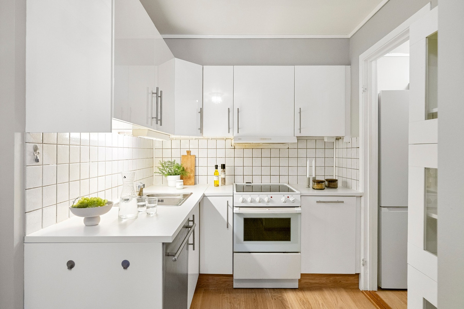 Fliser mellom overskap og benkeplate fungerer som en stilren backsplash. Galleribilde