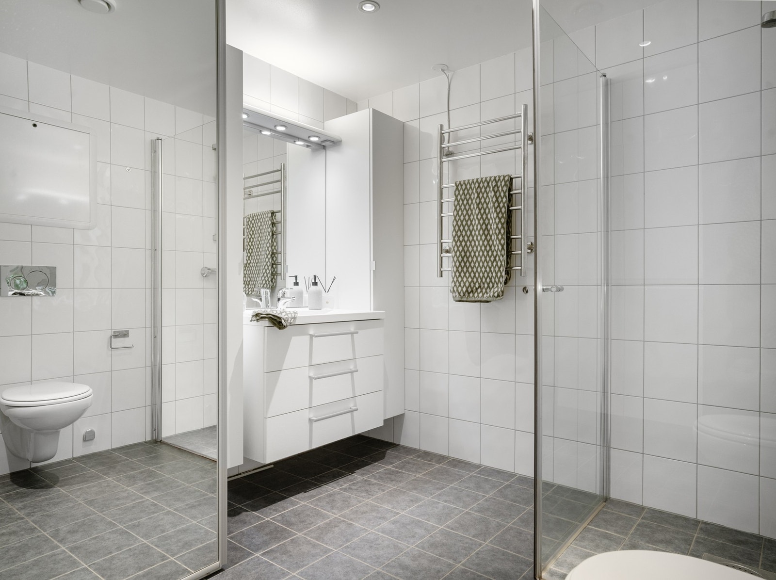 Bad med flislagte overflater og gulvvarme med god plass til vaskemaskin og tørketrommel. Galleribilde