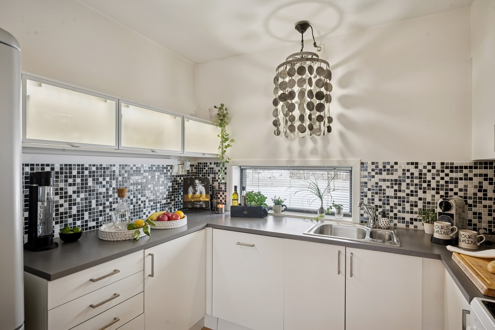 Kjøkkeninnredningen er fra byggeåret. Glatte fronter og en laminatbenkeplate med nedfelt kum i rustfritt stål. Galleribilde