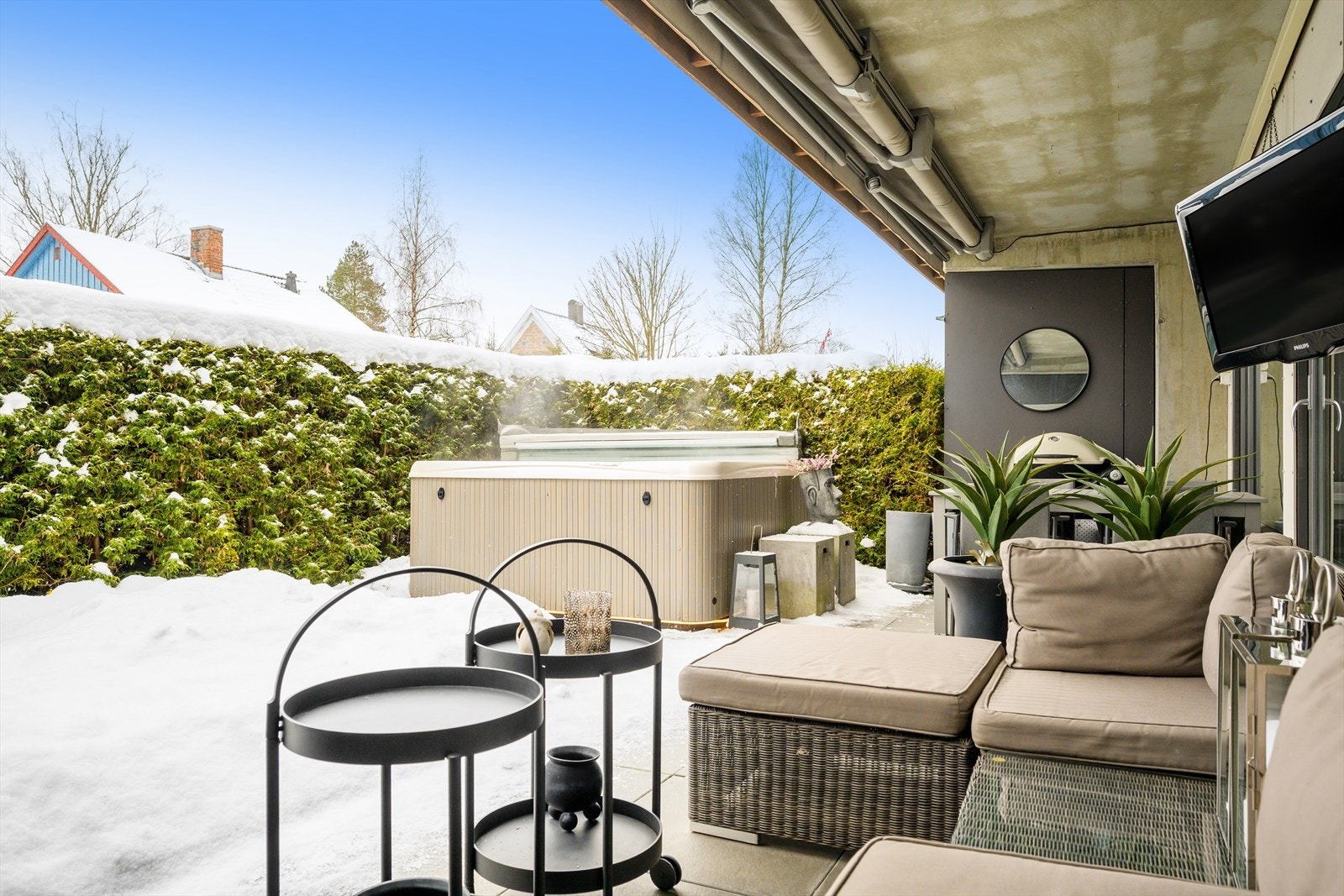 Elektrisk terrassemarkise som dekker hele uteplassen når den er utslått og medfølgende jacuzzi Galleribilde