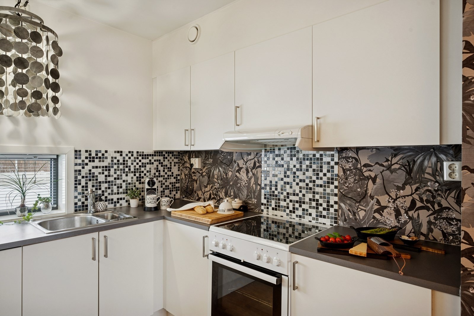 Tiltalende flis- og tapetvalg på veggen over benkeplaten. Galleribilde