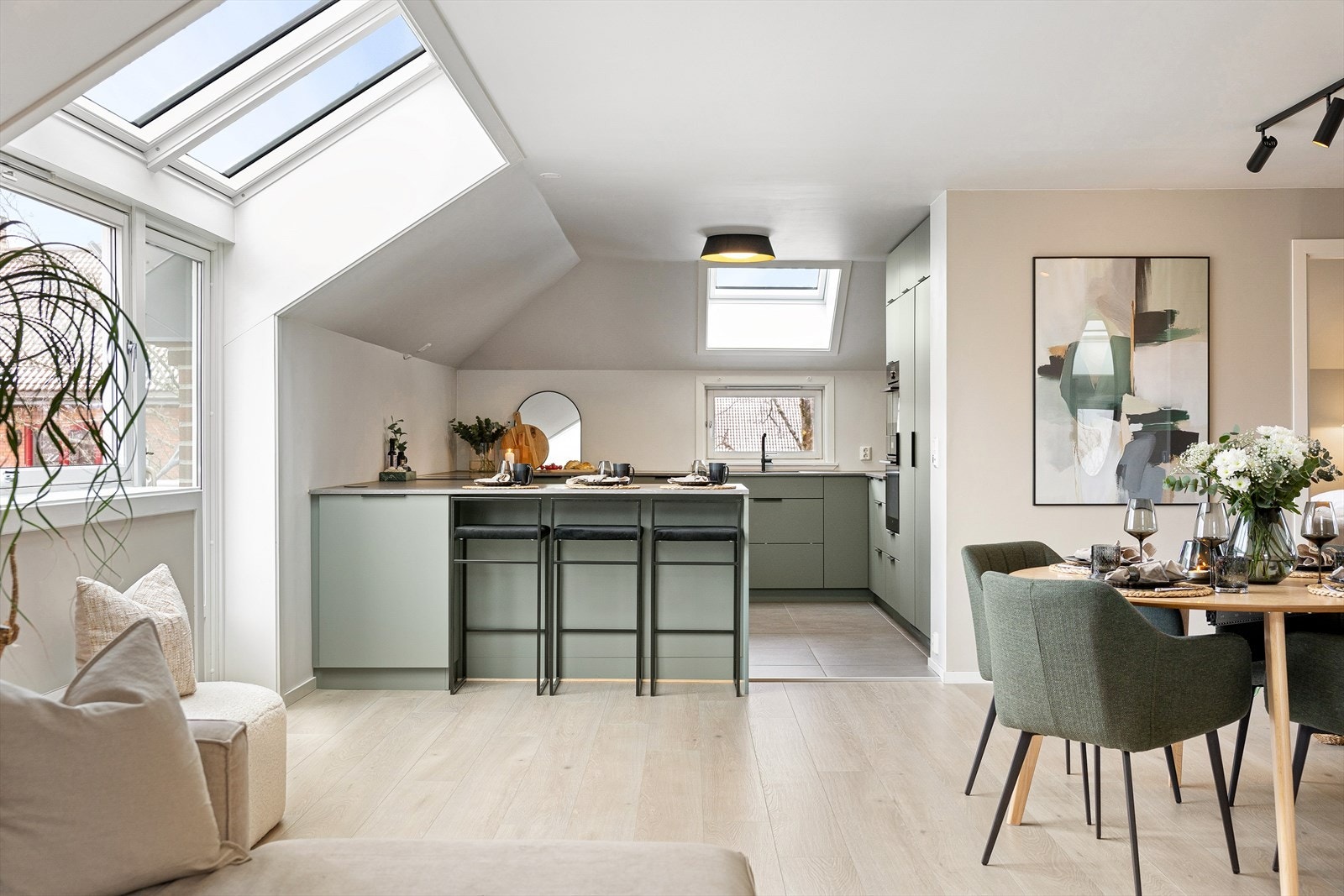 Kjøkkenet ligger i åpen løsning mot stuen, noe som gir en luftig romfølelse og legger til rette for en sosial sone hvor matlaging og opphold naturlig glir sammen. Galleribilde