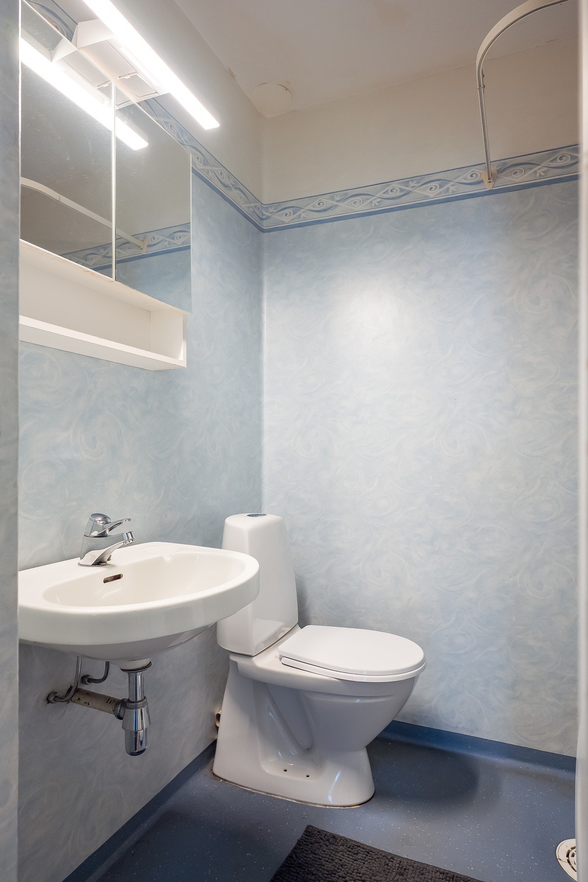 Badet består av speil med skap, dusjhjørnet, gulvmontert toalett. Galleribilde