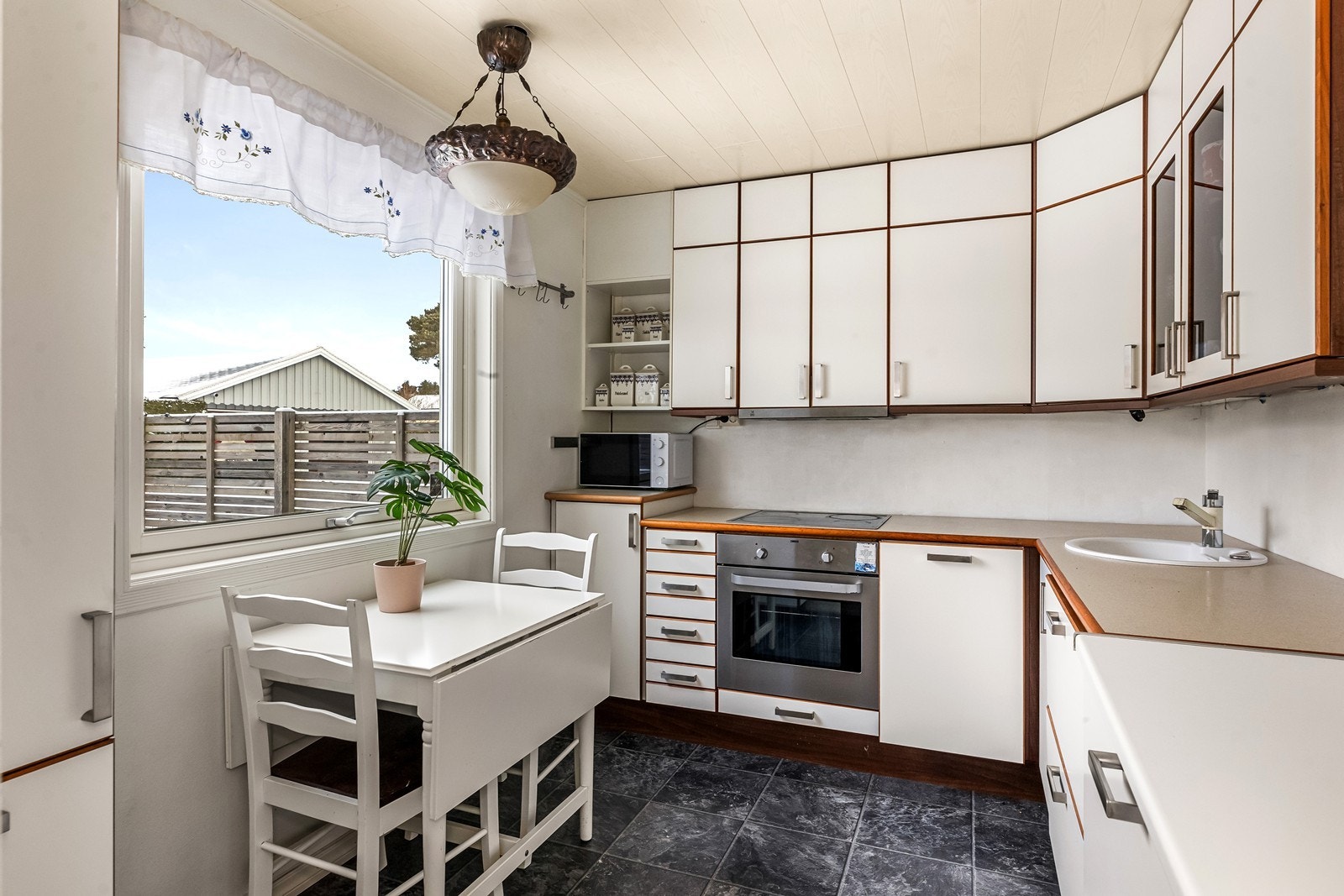 Kjøkkeninnredning med slette fronter og laminerte benkeplater. Galleribilde