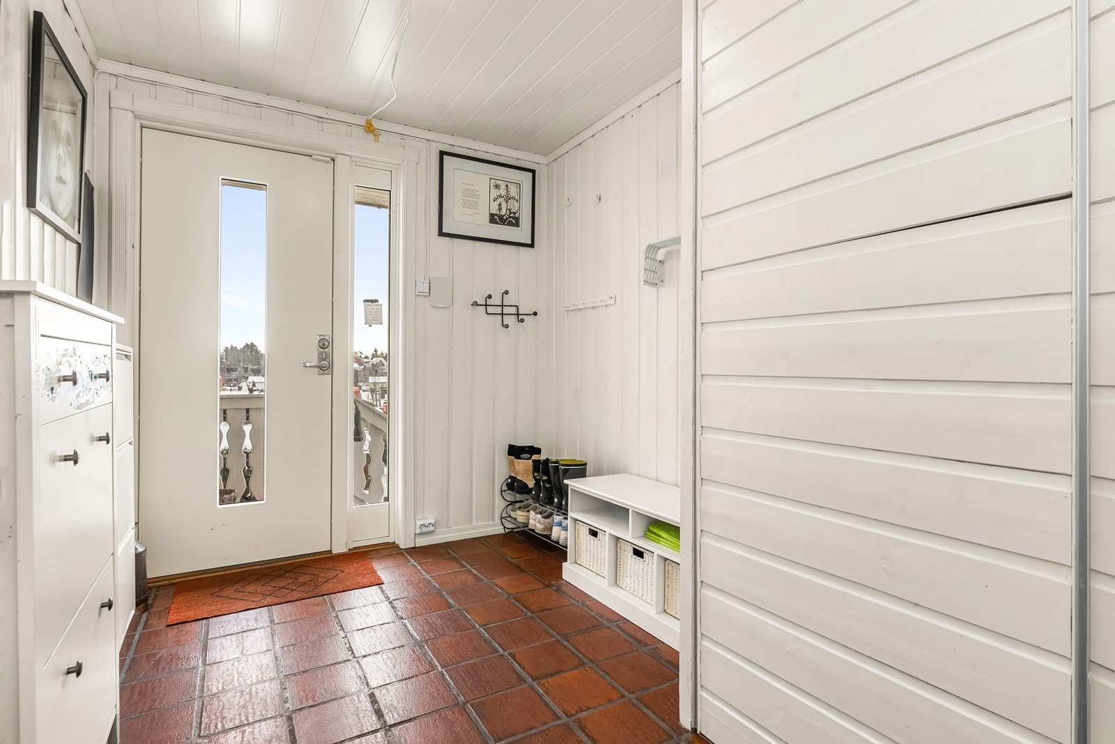 Innbydende entré med flislagt gulv og en praktisk, plassbygget skyvedørsgarderobe. Galleribilde