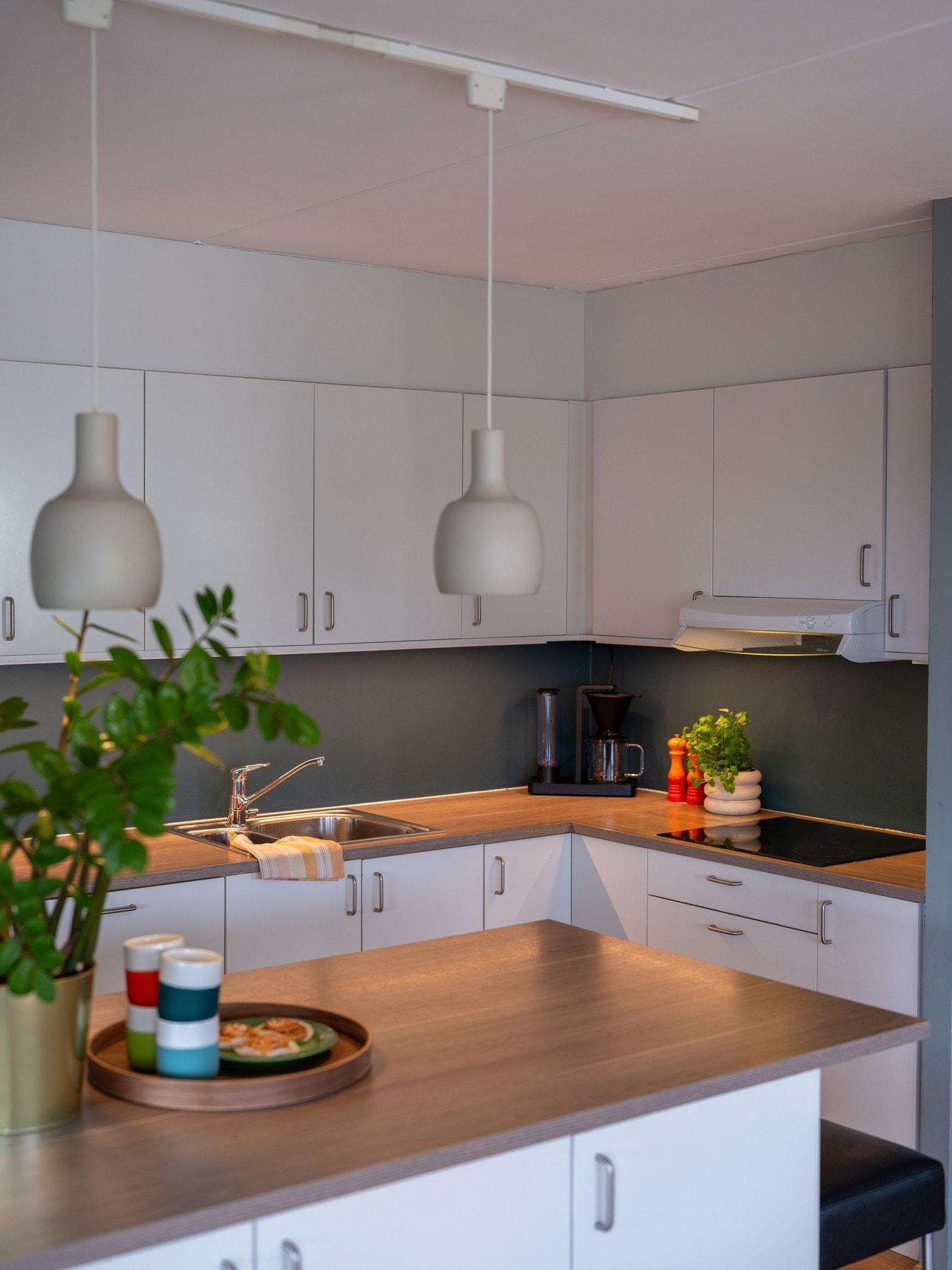 Lys innredning med slette fronter, laminat benkeplate og nedfelt oppvaskkum med ett-greps armatur. Galleribilde