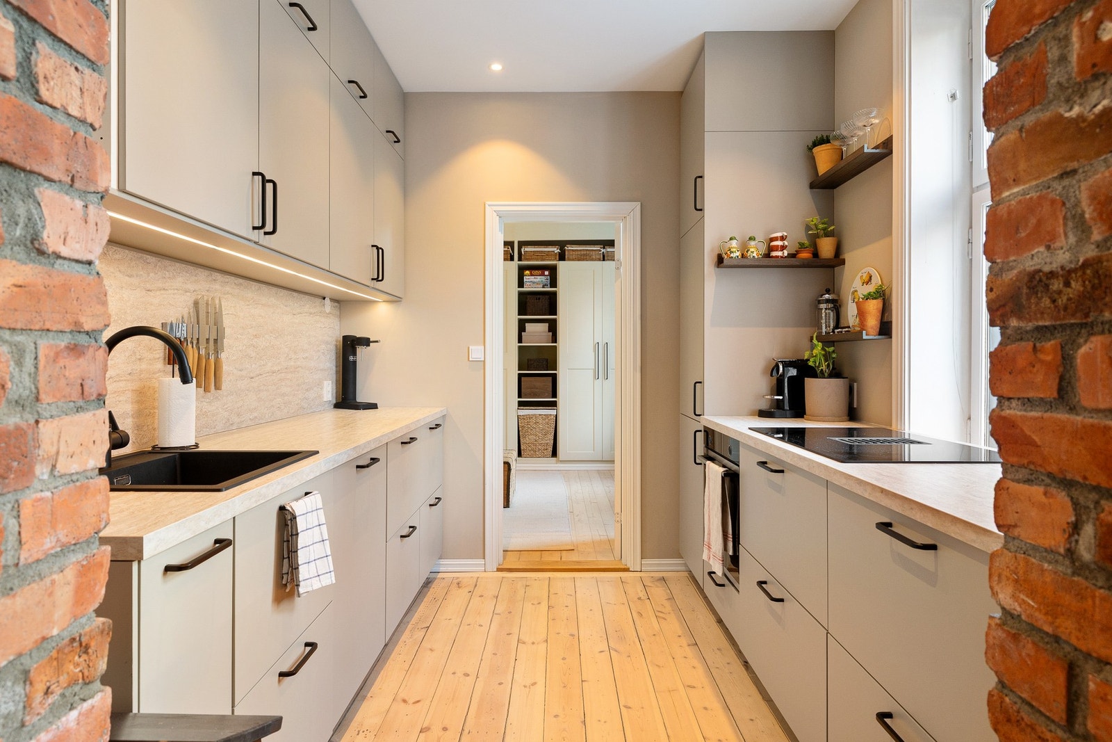 Moderne og stilrent kjøkken som ble flyttet og oppgradert for å gi en mer effektiv og sosial planløsning. Galleribilde