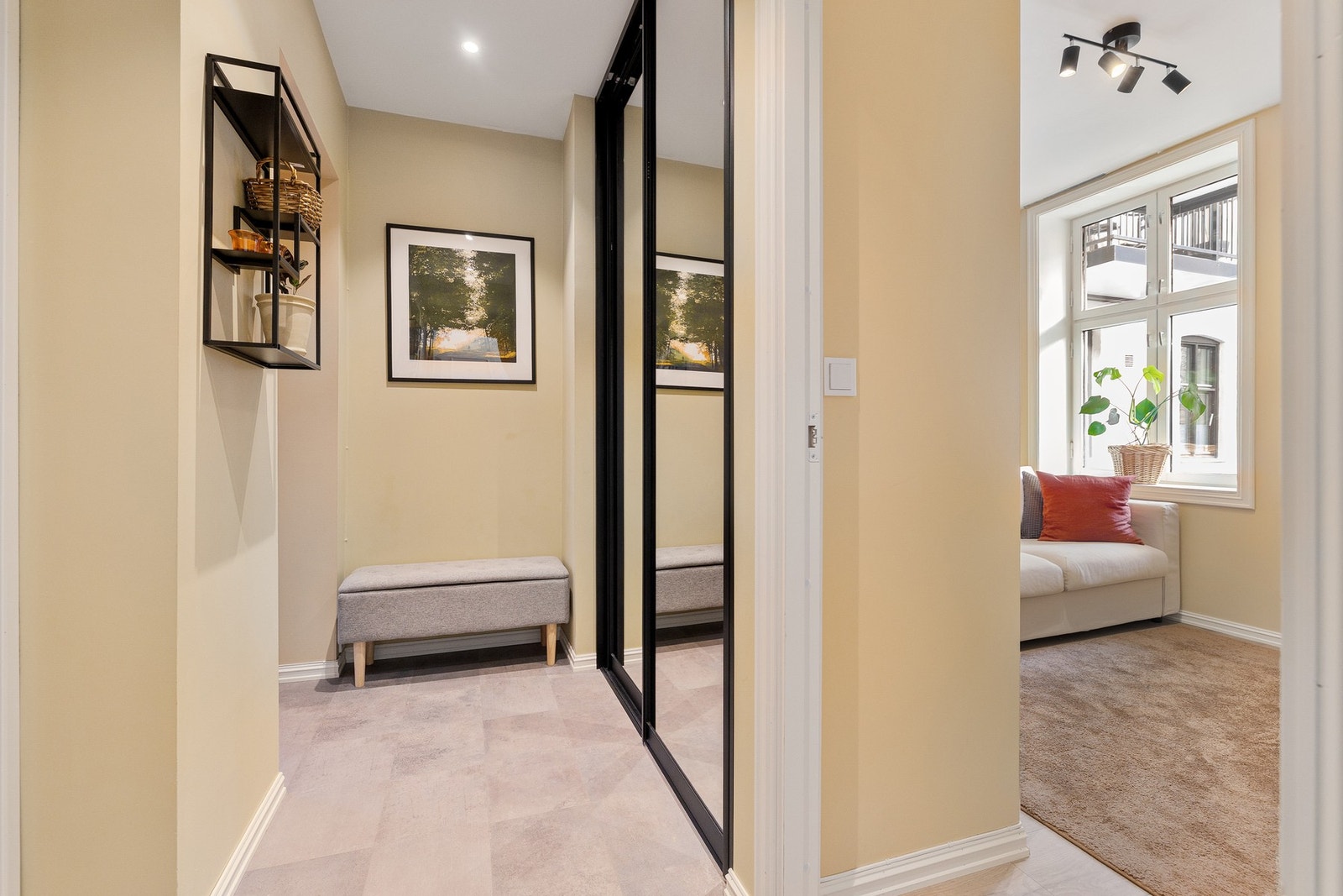 Lys og luftig entré som gir et godt inntrykk av leiligheten. Her er det et praktisk innebygget oppbevaringssystem samt knagger til å henge fra seg yttertøy. Galleribilde