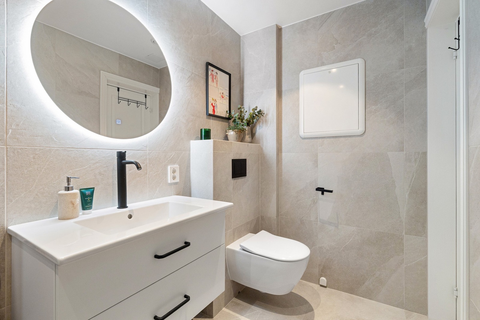 Badet har for øvrig dusjløsning med glassdører, servant med innredning og speil med belysning, samt gulvvarme for økt komfort. Galleribilde