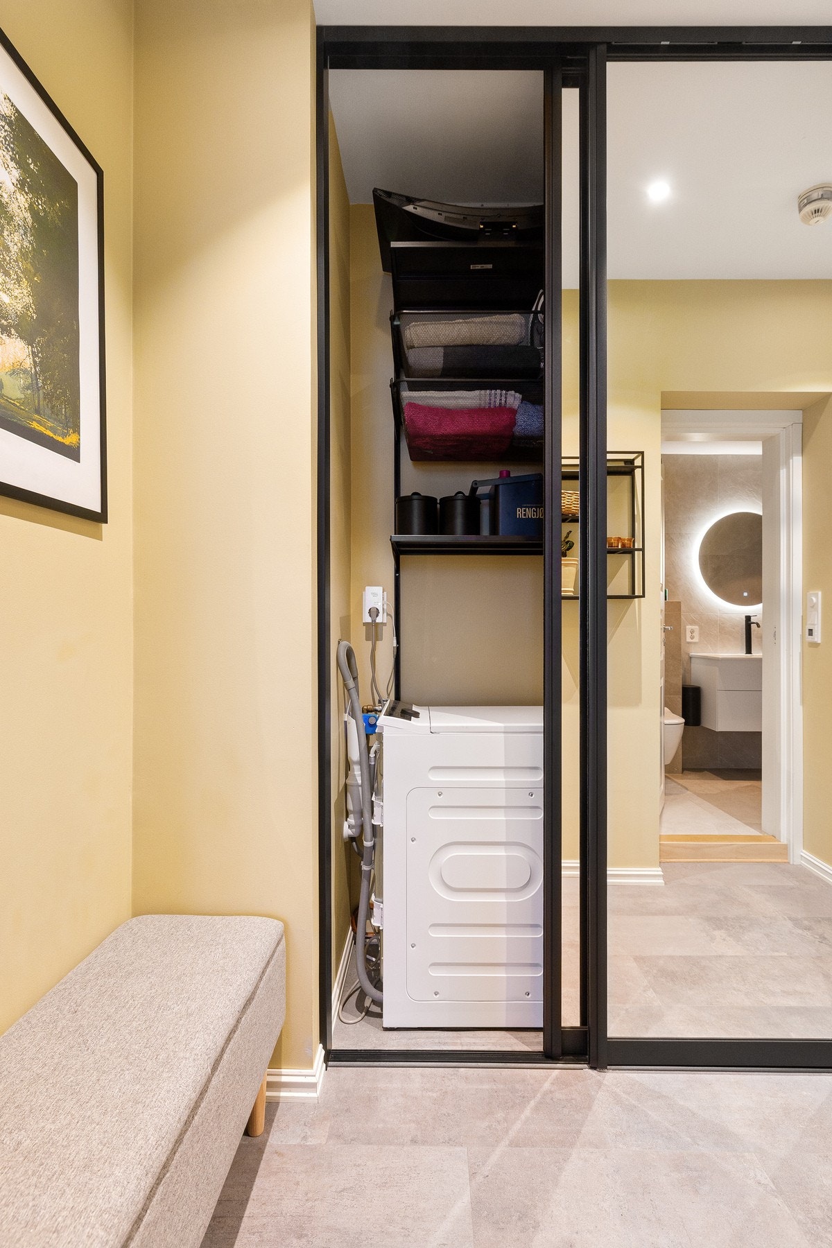 Vaskemaskinen er praktisk plassert i skap i gangen, noe som gir en fleksibel og arealeffektiv løsning uten å oppta plass på badet. Galleribilde