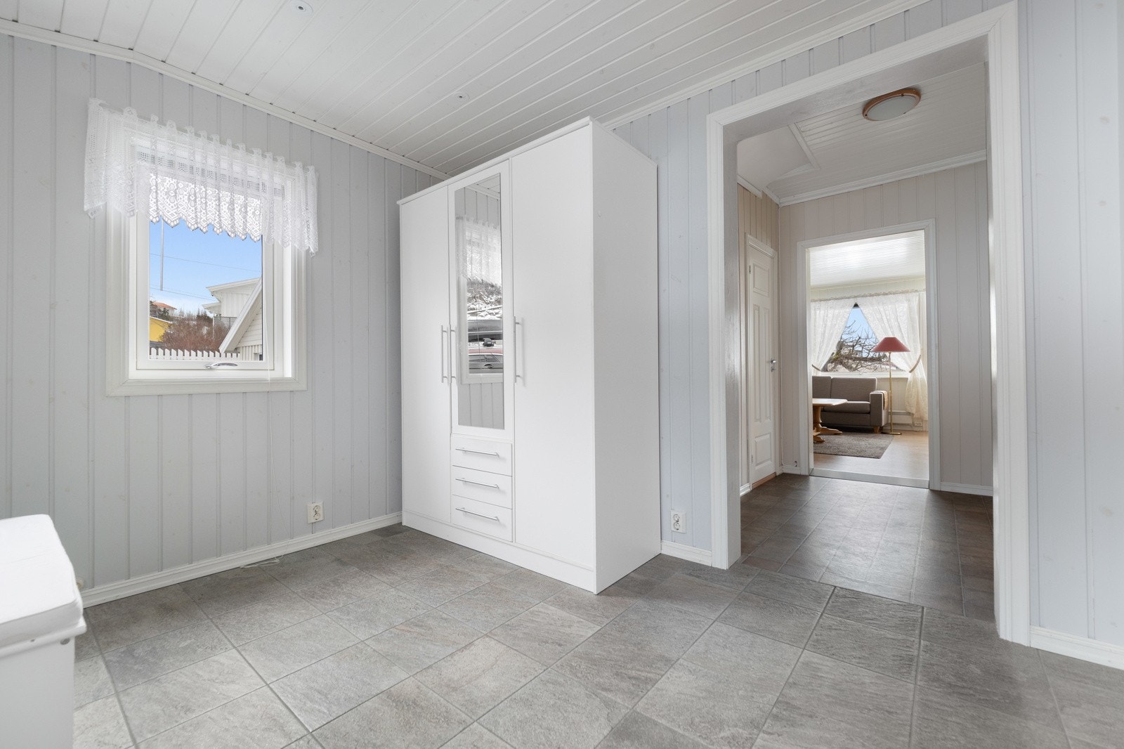 Romslig, flislagt entré med god plass til oppbevaring av jakker og sko Galleribilde