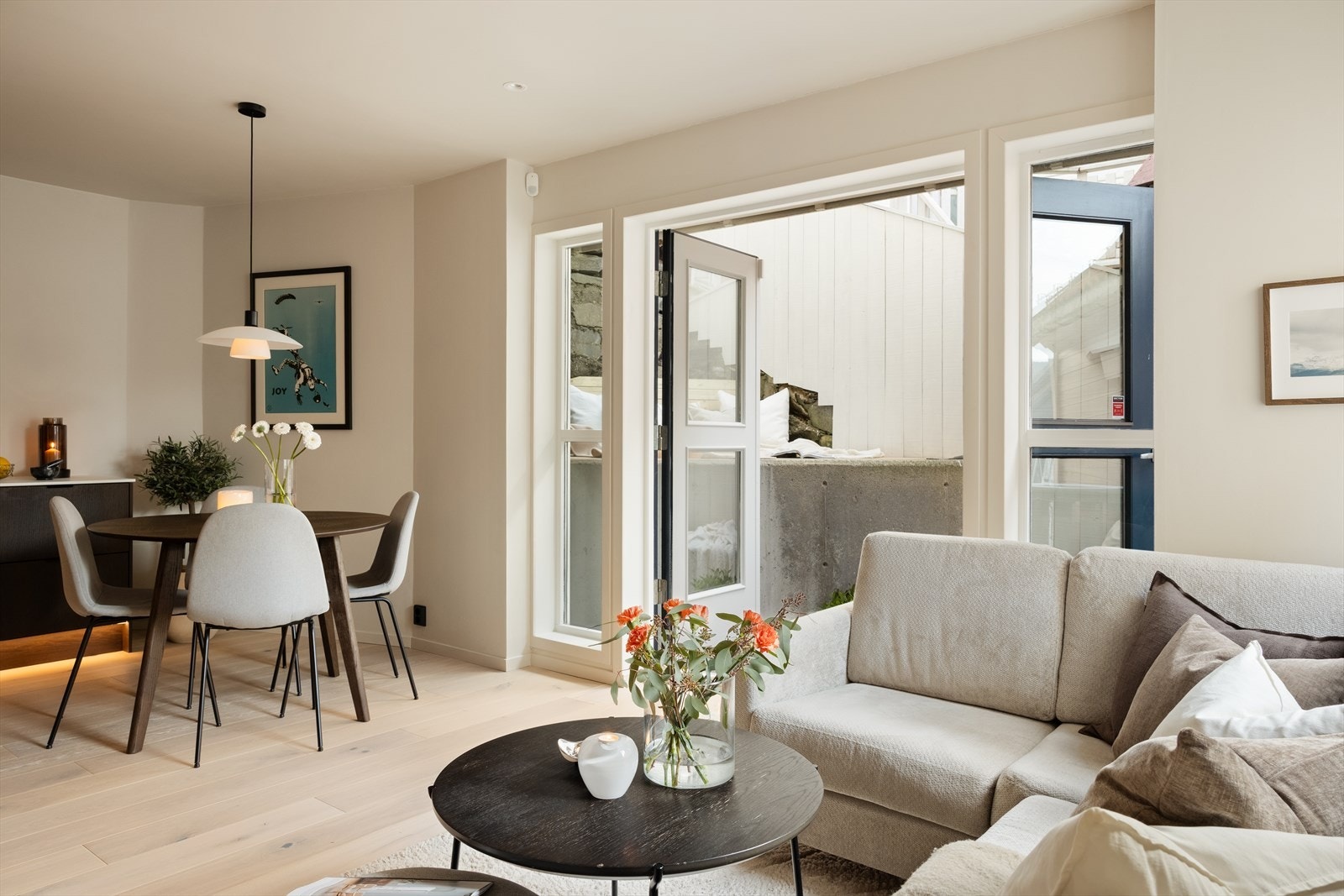 Store vindusflater slipper inn rikelig med naturlig lys, noe som skaper en lys og behagelig atmosfære gjennom hele dagen. Stue og kjøkken måler til sammen ca. 25 m² og oppleves som boligens naturlige samlingspunkt Galleribilde