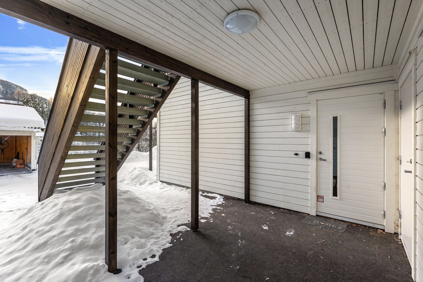 Overbygd inngangsparti som gir ly for vær og vind. Galleribilde